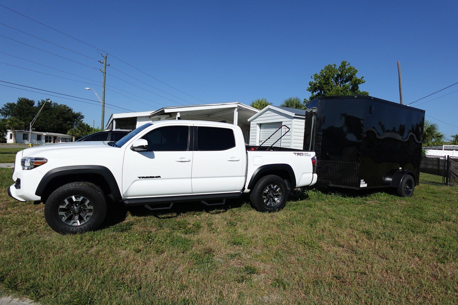 White work truck and enclosed black lawn care trailer