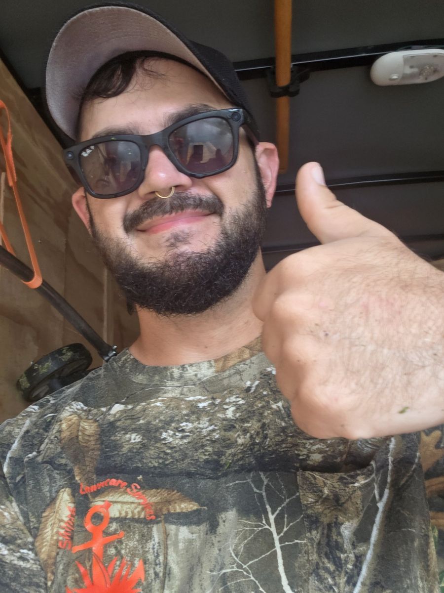 Collin, owner of Shipshape Lawncare Services, giving a thumbs up from his work trailer